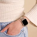 Close-up van een damespols met een smartwatch met Starlight Milanese bandje.