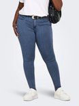 Model draagt een blauwe skinny jeans, witte t-shirt, zwarte riem en witte sneakers.