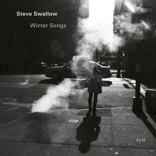 Pochette de l'album 'Winter Songs' de Steve Swallow. Une femme se tient dans une rue hivernale, de la vapeur s'élève.