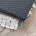 Donkergrijze achterkant van een snuffelmat met anti-slip noppen en rits. Rand met witte en lichtgroene stroken.
