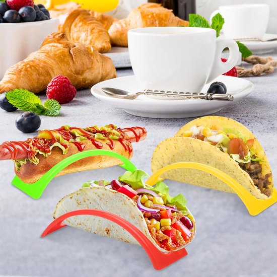 Gevulde taco's en een hotdog in rode, gele en groene houders op een tafel met ontbijtproducten.