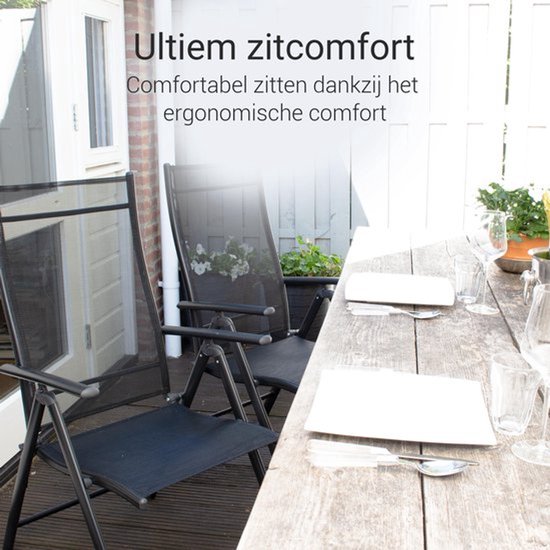 Twee zwarte, inklapbare tuinstoelen met textilene bekleding naast een houten tafel.