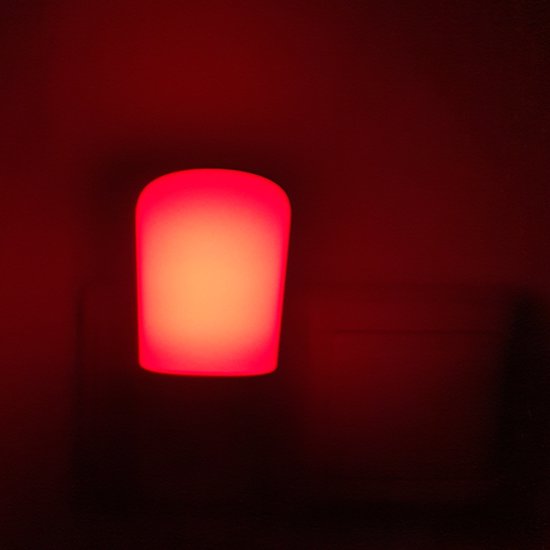 Rood nachtlampje, verlicht in het donker.