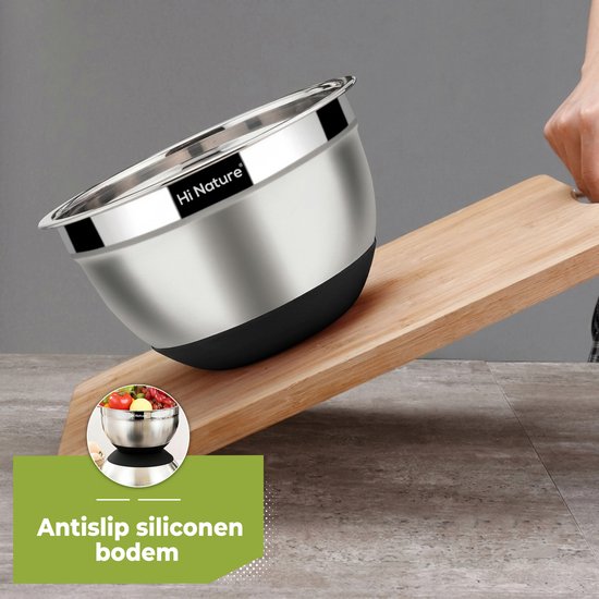 Roestvrijstalen mengkom met een antislip siliconen bodem, schuin op een houten plank, om zijn stabiliteit te tonen.