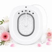 Wit URlife vaginale stoombad met handpomp, omringd door bloemen en een handdoek.