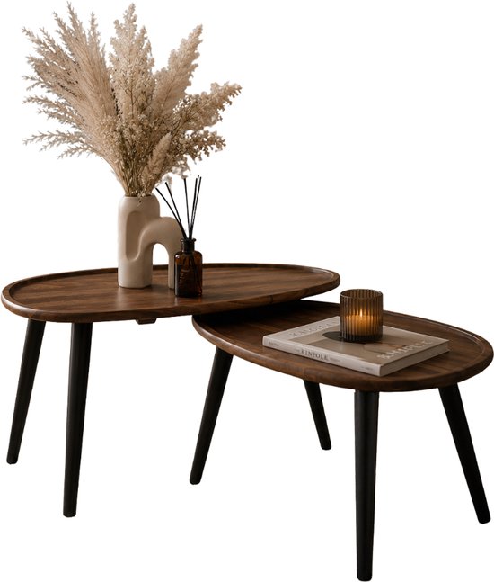Set van 2 bruine, houten bijzettafels met zwarte poten, gestyled met een vaas, pampasgras en kaarsen.