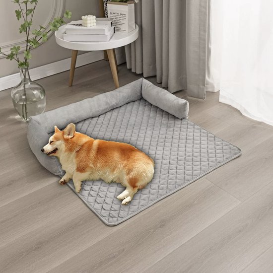 Grijze, gewatteerde bankhoes met armleuningen. Een corgi ligt op de hoes op de grond. De hoes is opgevouwen aan de zijkant.