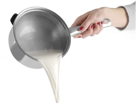 Een hand giet melk uit een roestvrijstalen steelpan.