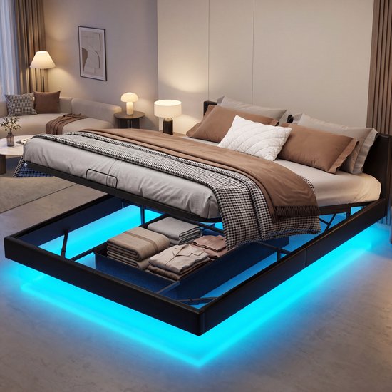 Zwart bed met opengewerkte bodem volgestapeld met opgevouwen dekens en kussens. Blauwe LED-verlichting eronder.