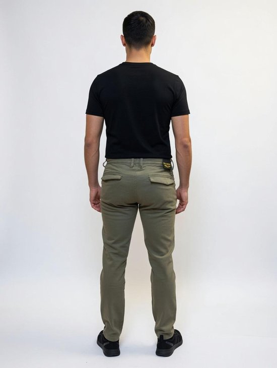 Man in zwart t-shirt en olijfgroene chino broek, gezien vanaf de achterkant.