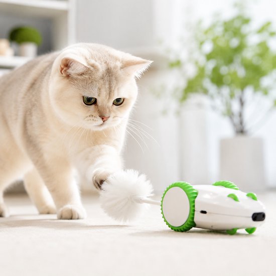 Een kat jaagt op een witte en groene robotmuis met een witte pluizige staart op de vloer.