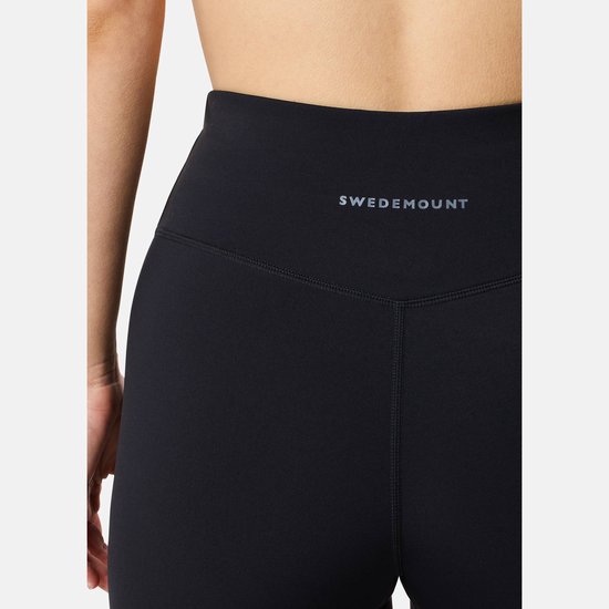 Close-up van de tailleband van een zwarte legging met 'SWEDEMOUNT' logo.