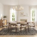 Rechthoekige houten eettafel met zes beige gestoffeerde stoelen in een woonkamer.