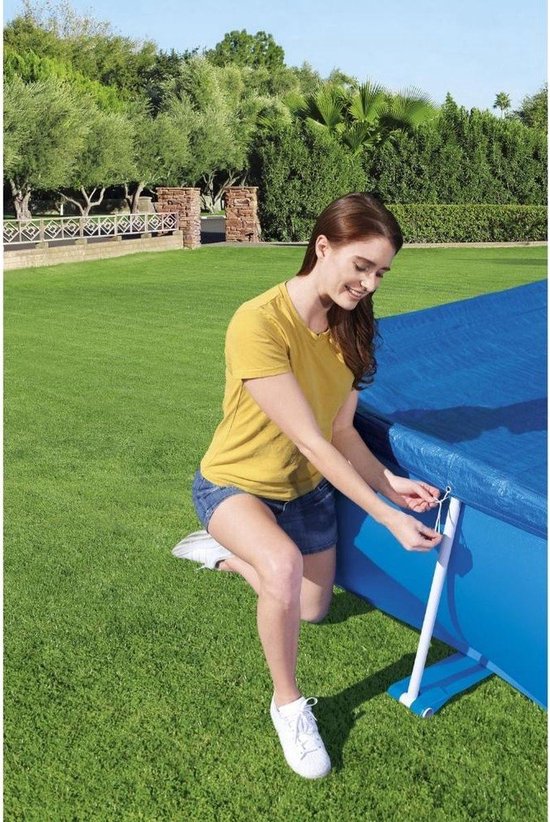 Vrouw strikt blauw zwembadafdekzeil van Bestway Steel Pro vast met touw aan het zwembadframe.