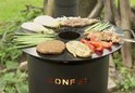 BonFeu tuinhaard met grillplaat, met erop gegrild vlees, groenten en een burger.