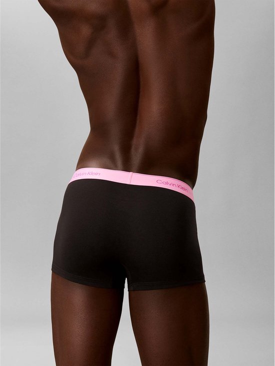 Achterkant van een man die Calvin Klein boxershorts draagt met roze logo band.