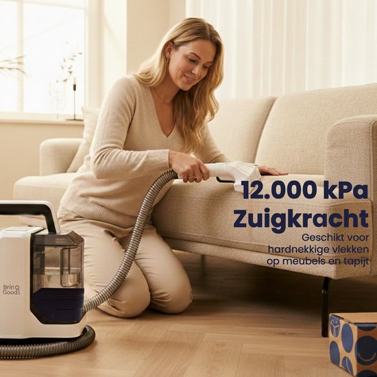 Een vrouw gebruikt een witte en zwarte vlekkenreiniger met een slang op een stoffen bank. "12.000 kPa Zuigkracht. Geschikt voor hardnekkige vlekken op meubels en tapijt."
