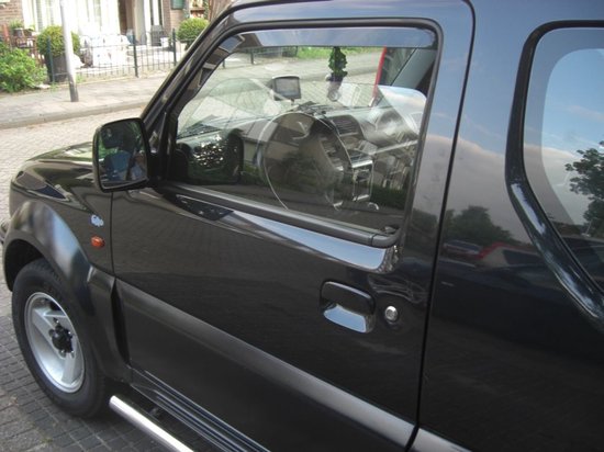 Zwarte Suzuki Jimny met donkere windschermen op de deuren. Model 1998-2018.