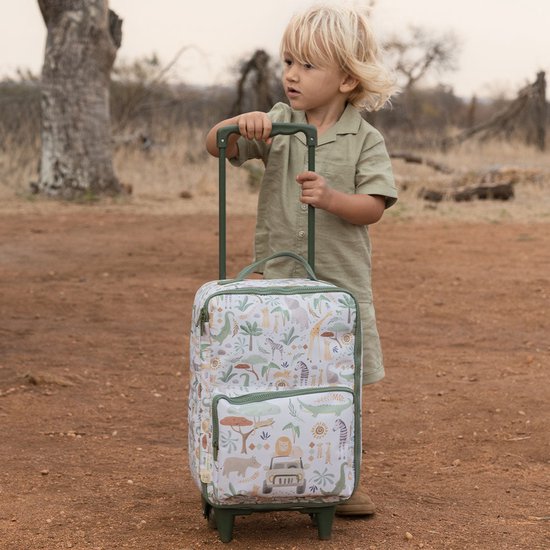 Jongetje met blonde haren in safari-kleding staat naast een koffer met safari print.
