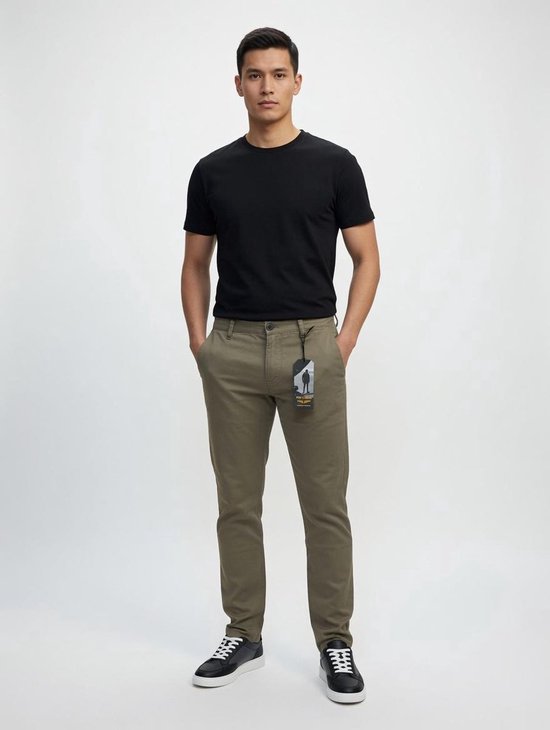 Man met de voorkant naar ons toe, draagt een zwarte t-shirt en een groene chino broek met een label aan de zijkant.
