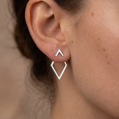 Model draagt zilverkleurige, open ruitvormige oorbellen met een klein driehoekje aan de oorlel.
