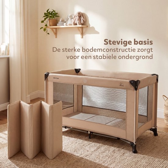 Beige Deryan campingbedje met gaaswanden en inklapbare bodemmat, in een woonkamer.
