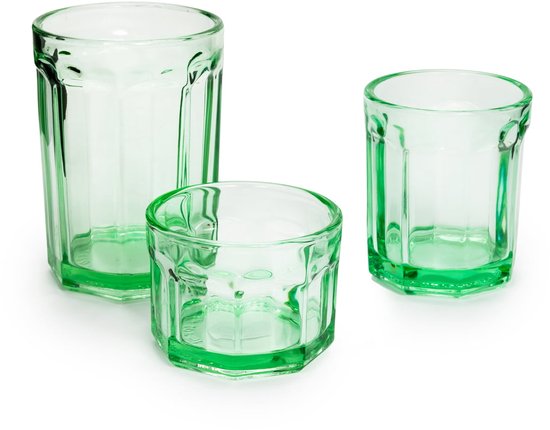 Drie groene, facetgeslepen glazen in verschillende formaten, op wit oppervlak.