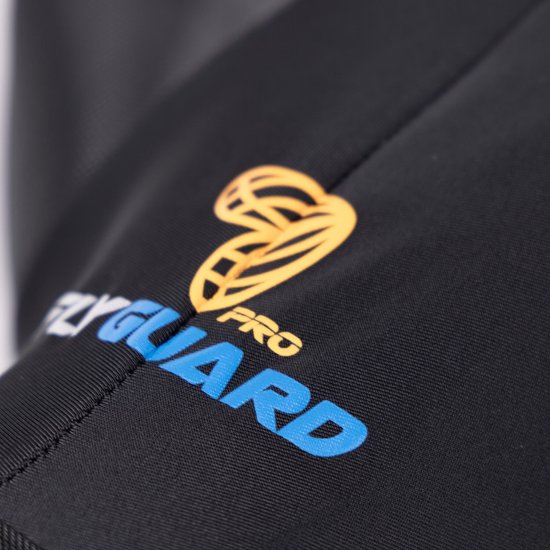 Detail van het zwarte vliegenmasker met de oranje en blauwe "FLYGUARD PRO" logo.