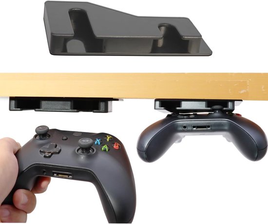 Zwarte controllerhouder bevestigd onder een bureau, met een Xbox controller eraan gehangen en een hand die een andere controller vasthoudt.