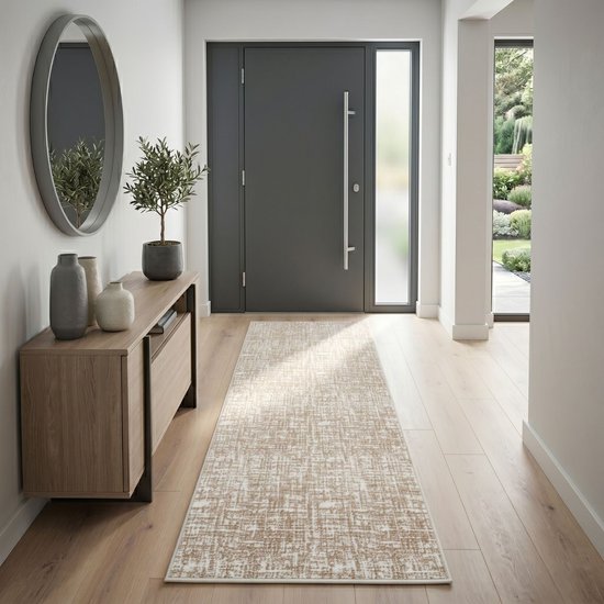 Un tapis de couloir beige à motif abstrait, posé dans un couloir devant une porte gris foncé.