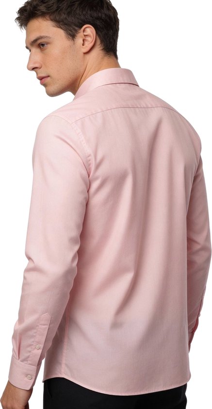 Model draagt een lichtroze slim fit overhemd met lange mouwen, van achteren gezien.