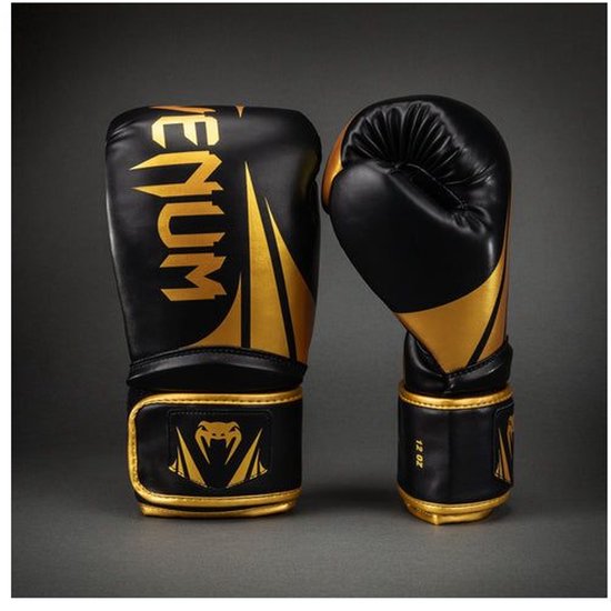 Twee zwarte bokshandschoenen met gouden "VENUM" logo en 12 OZ aanduiding.