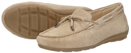 Paar beige suède mocassins, één schoen met zool, de andere met strikdetail.