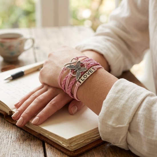 Roze gevlochten armband met vlinder- en infinity-bedeltjes, met het woord "LOVE".