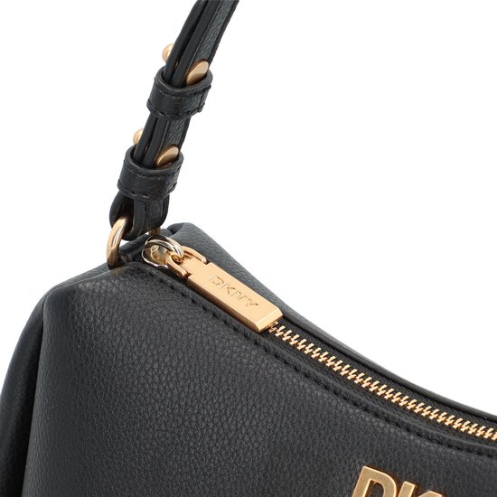 Close-up van de goudkleurige ritssluiting en het DKNY-logo op een zwarte tas.
