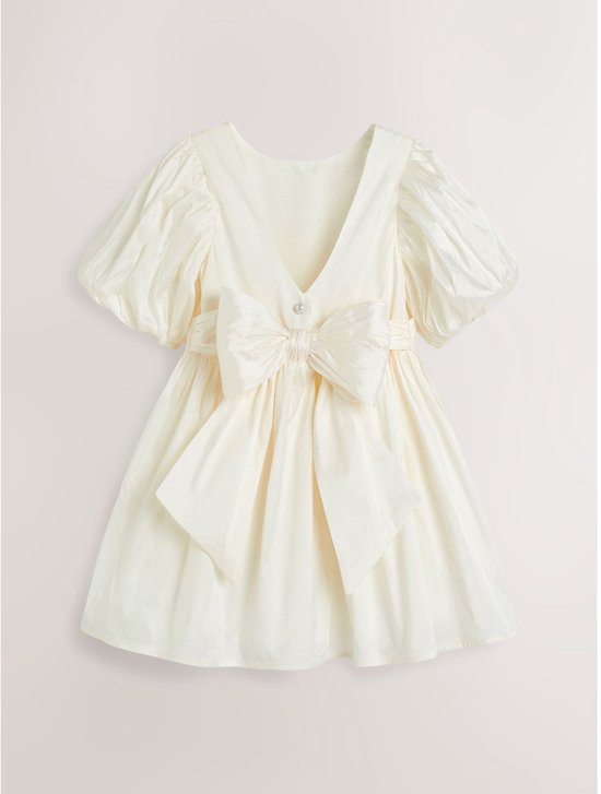Wit taffeta jurkje met korte pofmouwen, V-hals achterkant, grote strik en parel.