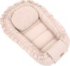 Beige babynestje met ruches, kussen en label 'Soosie'.
