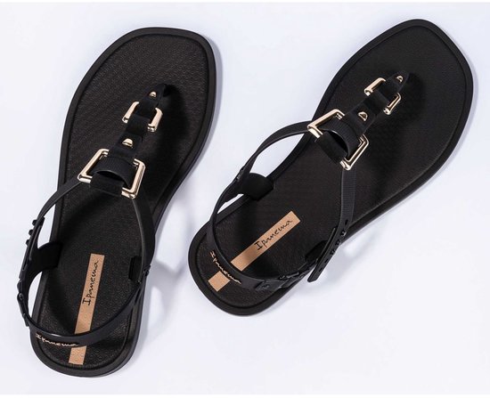 Zwarte Ipanema teenslippers met goudkleurige gespen en bandjes.