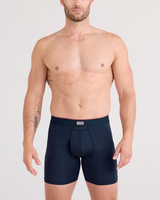 Man met donkerblauwe SAXX boxer briefs met rode rand en logo.
