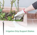 Een hand met een witte handschoen plaatst een druppelslanghouder in een bloempot bij planten. De tekst 'Irrigation Drip Support Stakes' staat onderaan.
