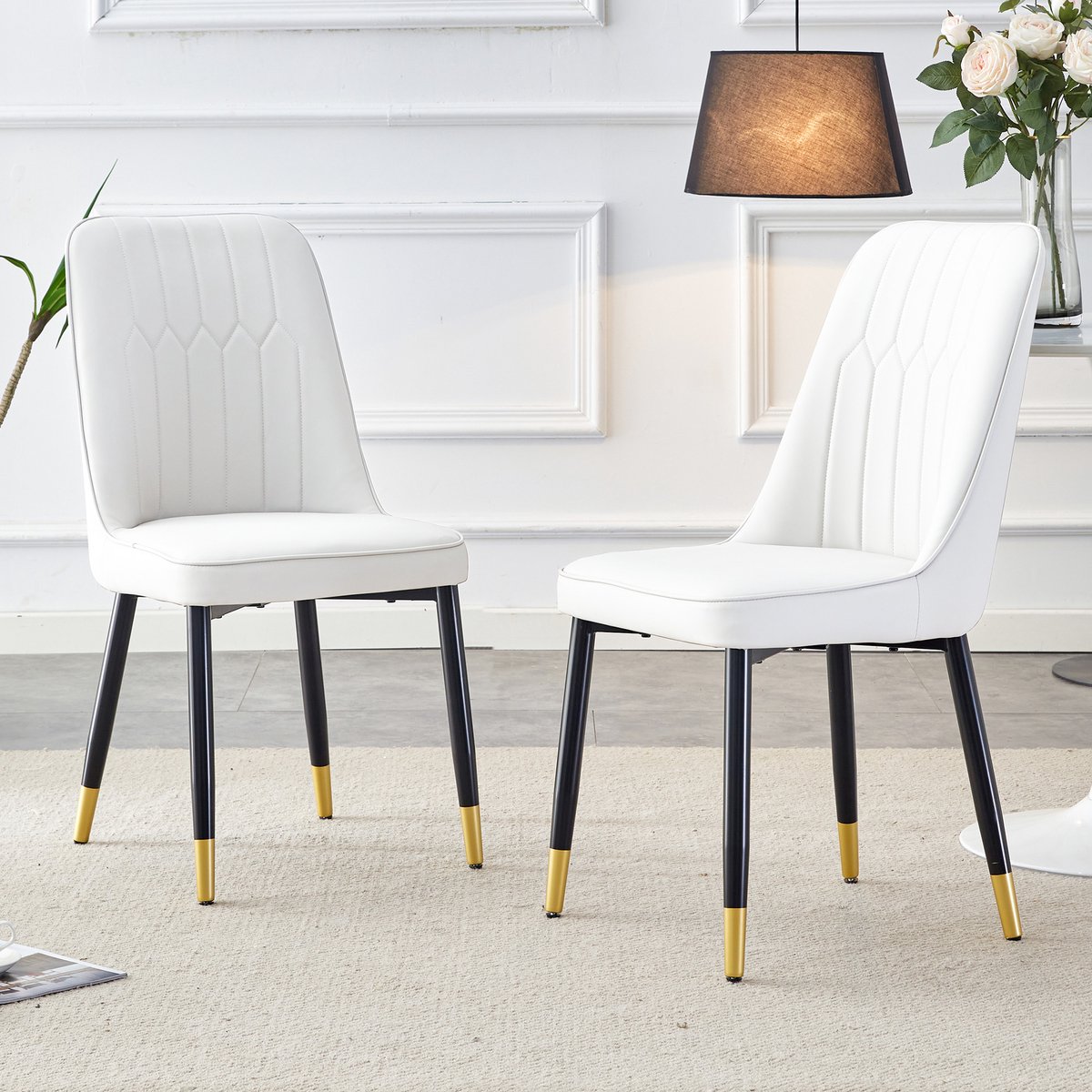 Set van 2 moderne witte eetkamerstoelen met witte PU-leren rugkussens en zwarte metalen poten, geschikt voor diverse ruimtes zoals de eetkamer, keuken en slaapkamer.
