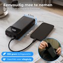 Zwarte powerbank van 14,5cm x 6,7cm x 2,8cm, 390 gram, naast een smartphone.