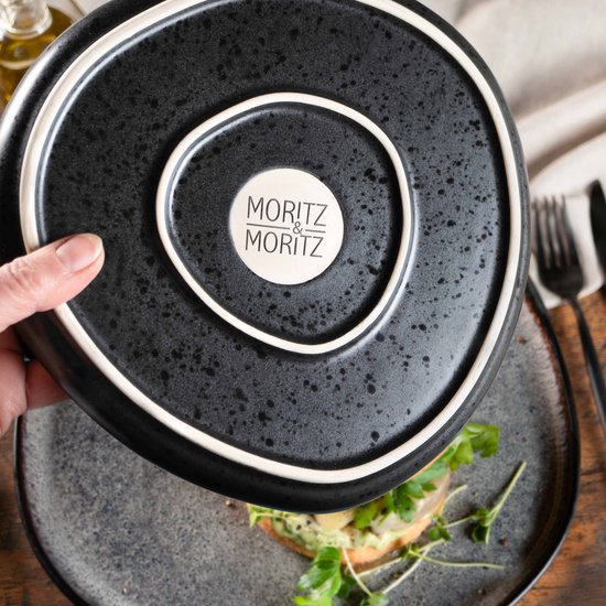 Hand die een grijs bord optilt, met het Moritz & Moritz logo aan de onderkant.
