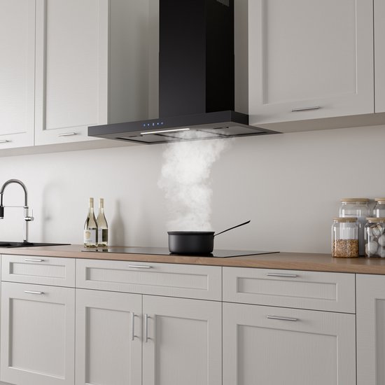 Zwarte afzuigkap boven een kookplaat in een keuken, met opstijgende rook uit een pan.