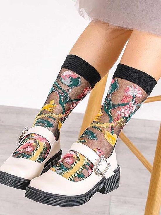 Dames enkelsokken van transparante stof met roze en gele bloemenprint en zwarte boord.