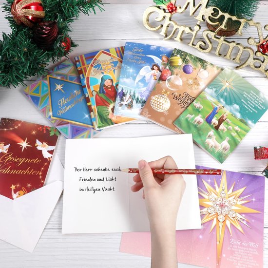 Hand schrijft kerstgroet in een open kaart tussen diverse kerstkaarten en een gouden Merry Christmas-versiering.
