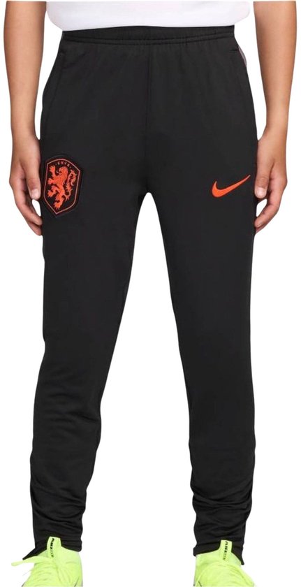Jongen in zwarte Nike trainingsbroek met oranje logo en KNVB-embleem.