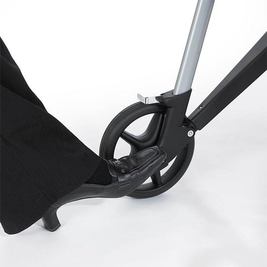 Voet drukt op de rem van een grijze rollator met vier wielen.
