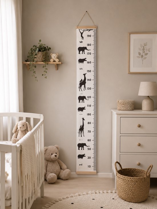 Groeimeter met silhouetten van savannedieren, hangend in een kinderkamer naast een ledikant.