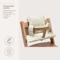 Gedetailleerde zitverkleiner met bloemenpatroon op een houten kinderstoel, met beige zitting en rugleuning.